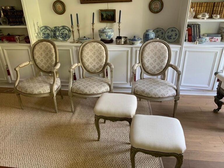 Suite de trois fauteuils à dossier médaillon cabriolet en bois laqué blanc mouluré et sculpté de dés de rosace