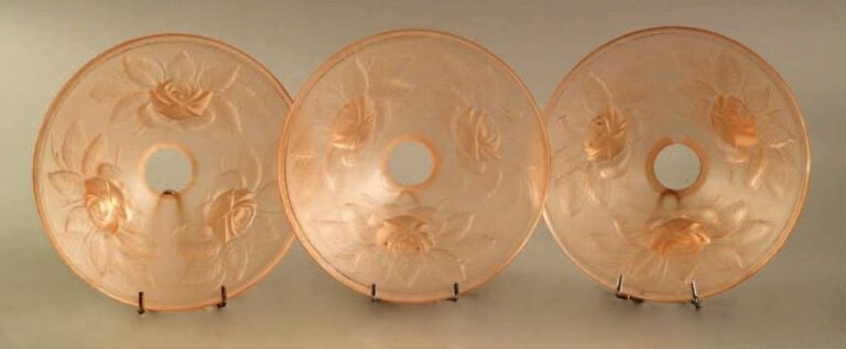 Suite de trois petits abats-jours en verre rose à décor moulé de rose