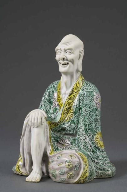 SUJET EN BISCUIT EMAILLE POLYCHROME DANS LE STYLE DE LA "FAMILLE VERTE" MOULE A L'EFFIGIE D'UN LOHAN ASCETE Chine, Epoque XXe siècle Assis en rajalalisana, la jambe droite repliée au devant, le main droite sur le genou droit, la jambe gauche repliée au dessous, une lourde tunique sur son do