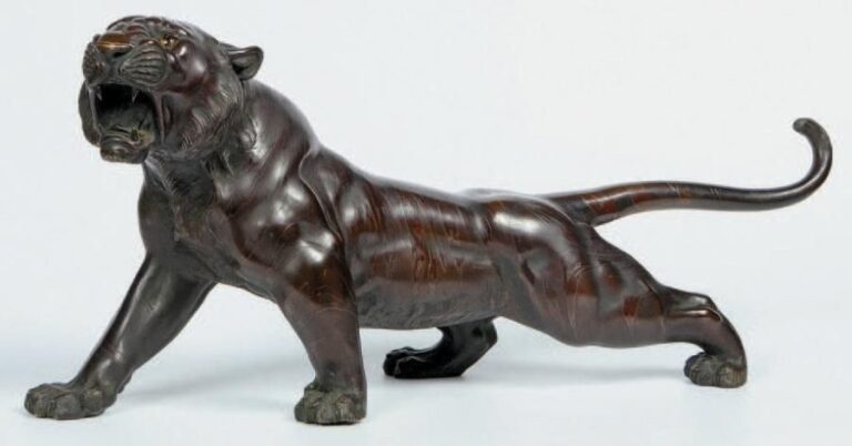 Sujet en bronze de patine brune représentant un tigre marchant et rugissant, les yeux en sulfur