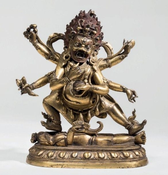 Sujet en bronze doré représentant le dharmapâla Mahâkâlâ à l'expression féroce, debout sur un lotus, piétinant un être à tête d'éléphant, ses six bras tenant ses attributs, à savoir cintamani, kapala, karttrika, damaru, ankusa et trisul