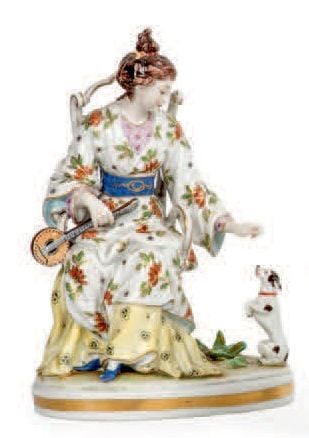 Sujet en porcelaine polychrome représentant une musicienne récompensant son chie
