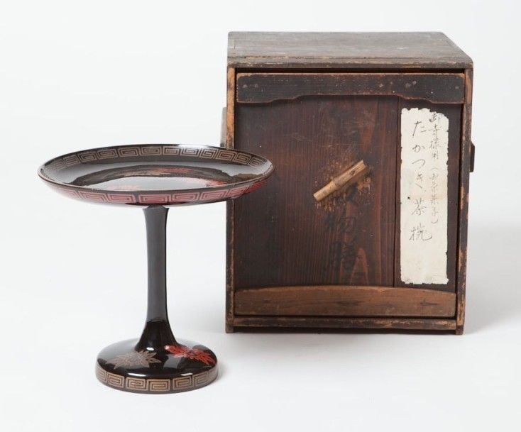Support d'autel laqué noir sur un socle à décor de feuilles dorées et rouge