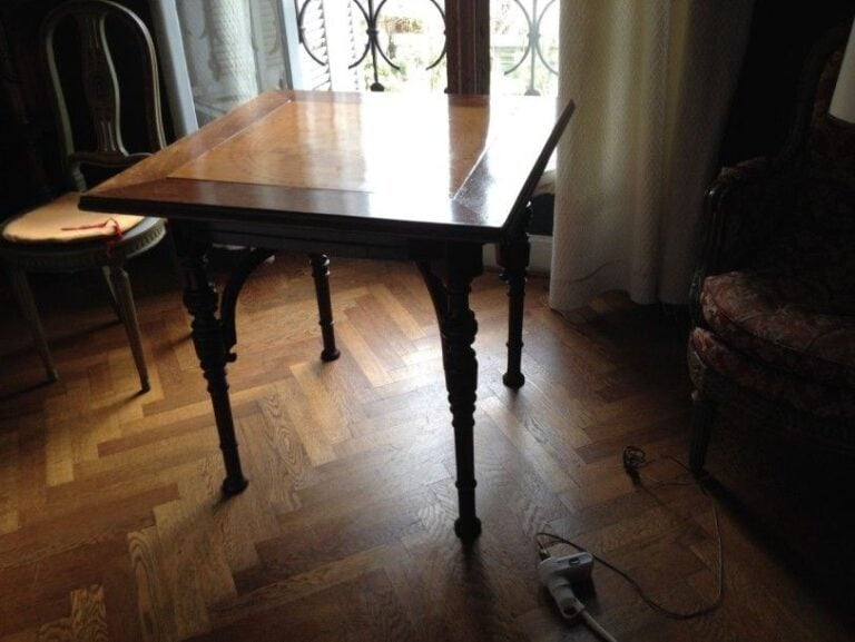 TABLE A JEUX DE STYLE HENRI II EN BOIS NATUREL, les pieds à toupies, le tablier ouvrant par quatre tiroirs / tirettes, le plateau de section carrée centré d'un damier en bois fruitier aux côtés mesurant 56 cm (fêles, soulèvements au damier et petits manques