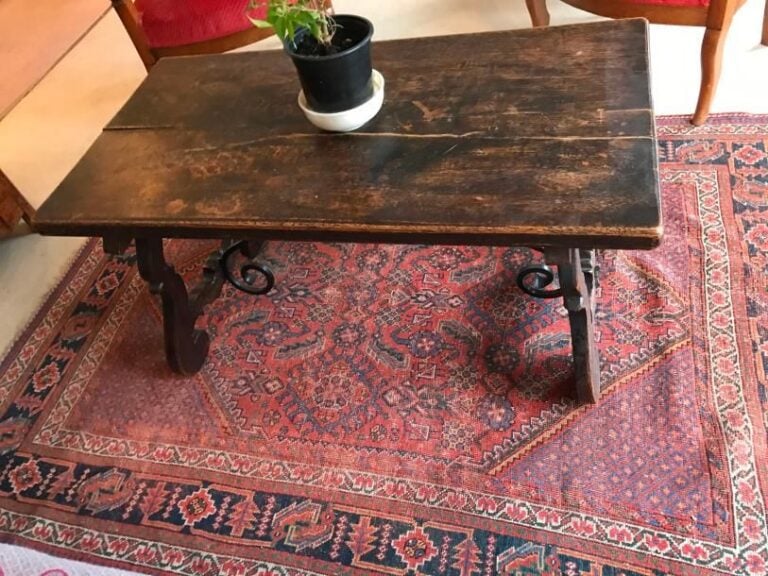 Table basse en bois naturel à pieds en volute réunie par une entretoise en fer forgé