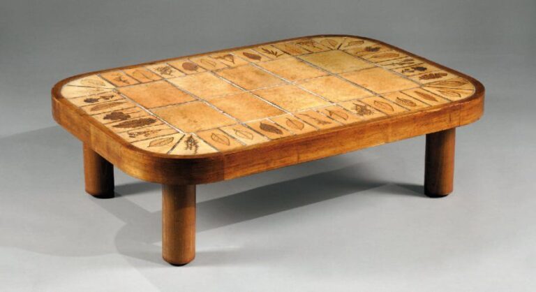 Table basse, modèle « Sho gun » à monture en bois naturel et plateau ovalisé à fond de dalle de grès chacune, en brodure, à décor d'empreinte de feuille