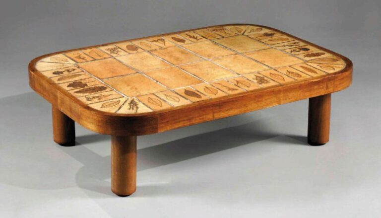 Table basse, modèle « Sho gun » à monture en bois naturel et plateau ovalisé à fond de dalle de grès chacune, en bordure, à décor d'empreinte de feuille