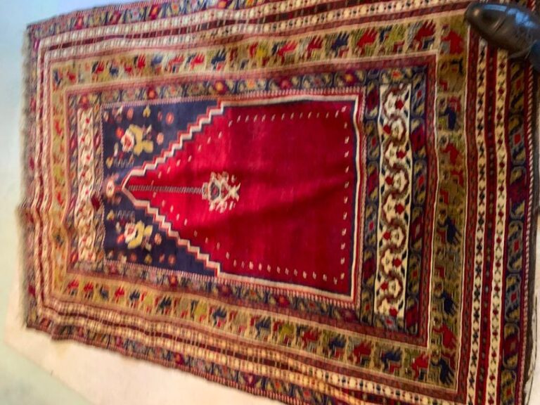 Tapis d'orient à décor de mirhab sur fond rouge avec lampe de mosquée