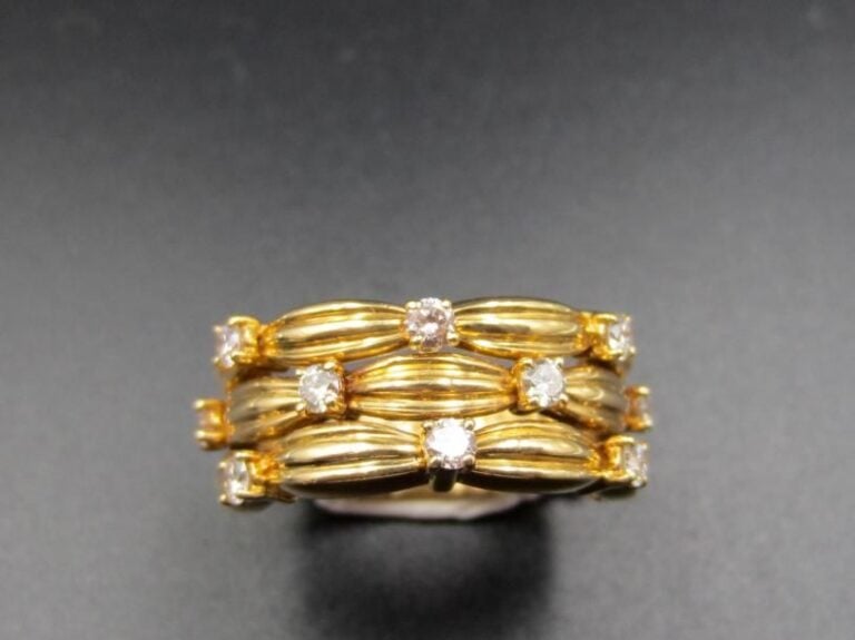 TIFFANY & Co             BAGUE en or jaune (750 millièmes) ajouré partiellement de trois rangs godronnés alternés de diamants taille brillant        Signé TIFFANY & Co, datée 1992             Doigt : 58        Poids brut : 11,3 g