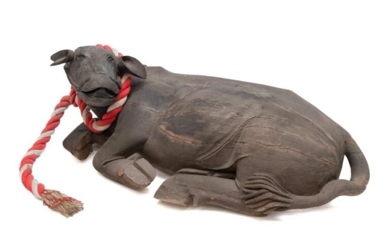 Très grande et rare figurine en bois représentant un bœuf allongé, une corde accrochée autour de son co