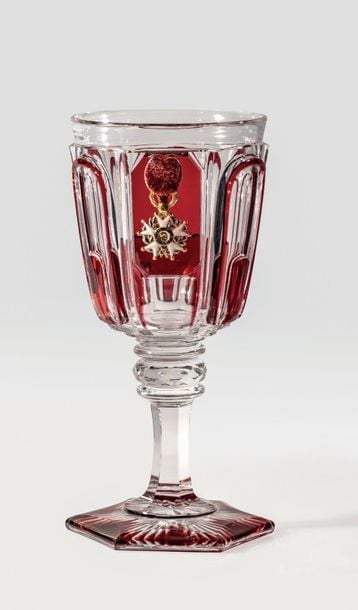 Très rare verre à pied en cristal overlay rouge taillé à sept panneaux, bouton à facettes et motif rayonnant sous le pied hexagonal, orné d'un motif émaillé sur paillon d'or représentant une croix d'officier de la Légion d'Honneur de la 2e République, présentant au centre le profil de Bonaparte 1er consu