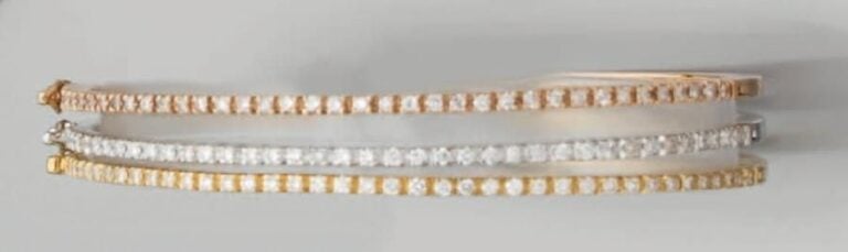 Trois BRACELETS rigides ouvrant, trois ors, sertis d'un alignement de diamant