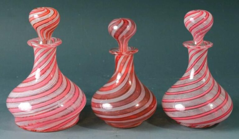Trois flacons piriformes et leurs bouchons à décor spiralé de rubans roses alternés de filigranes blanc