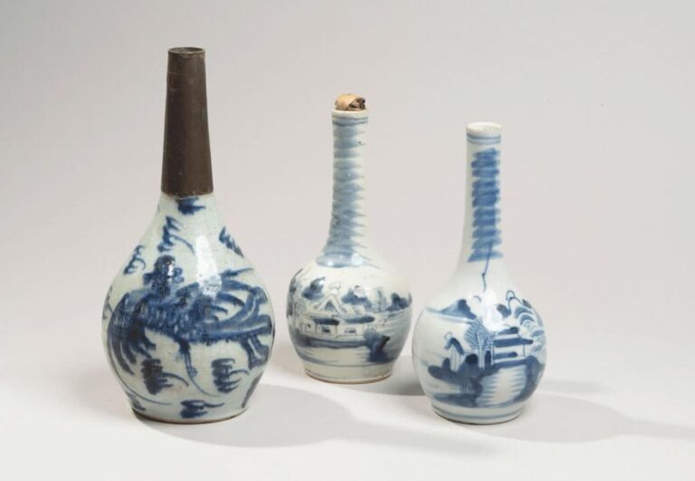 Trois petites bouteilles en porcelaine à décor en bleu sous couverte de paysages lacustres et phéni