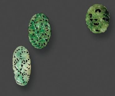 Trois petits boutons en jadéite de forme ovoïde finement sculpté et ajouré à décor d'oiseaux d'amour, de cigognes, et de dragon