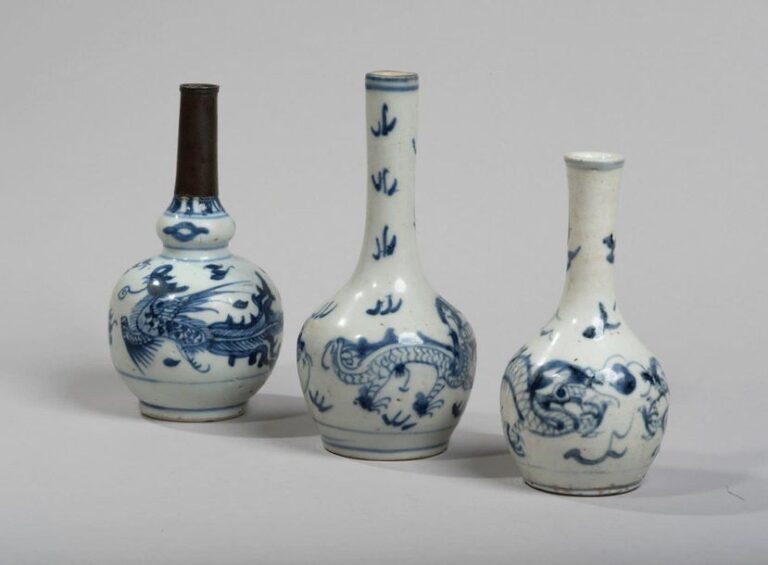 Trois petits vases bouteilles en porcelaine décorée en bleu sous couverte, de deux dragons et d'un phénix