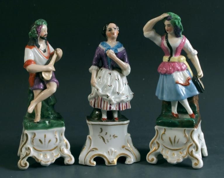 Trois pique-fleurs en porcelaine représentant un musicien jouant de la mandoline, une danseuse tenant un tambourin et une jeune femm