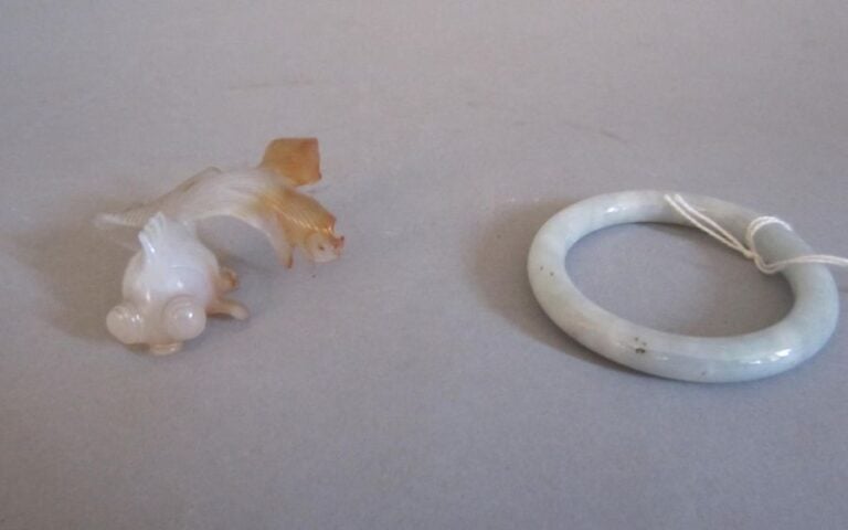 Un bracelet en jade et un poisson combattant en jade