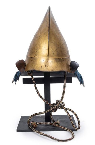 Un casque eboshinari recouvert de cuir laqué or du 17 ème siècle, avec de petits fukikaeshi laqués noirs et quatre protège-nuques (shikoro) avec des cordons indig