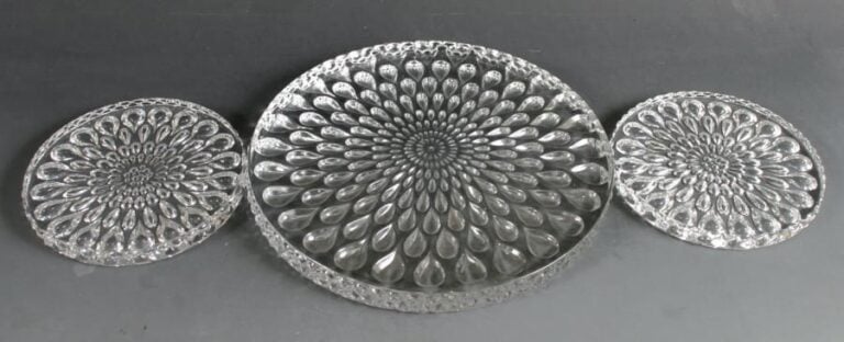 Un dessous de plat et deux dessous de bouteille en cristal moulé à motif de dégradé de gouttes rayonnante