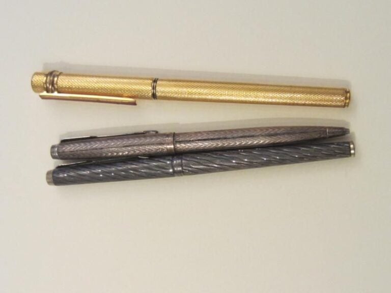 Un stylo Cartier plaqué or et deux stylos argent