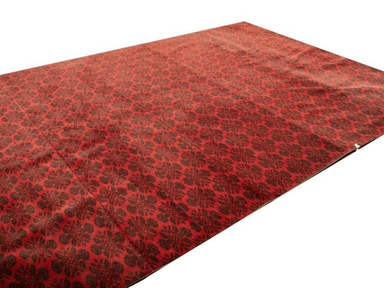 Un tapis de moquette, fond rouge à motifs noirs