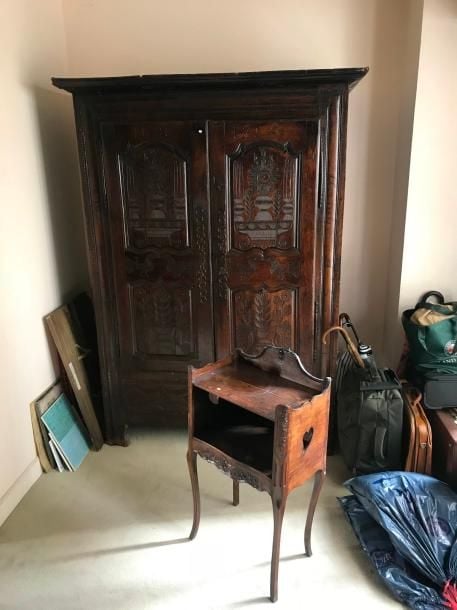 Une armoire en chêne teinté à décor mouluré et sculpté de motifs floraux et rinceau