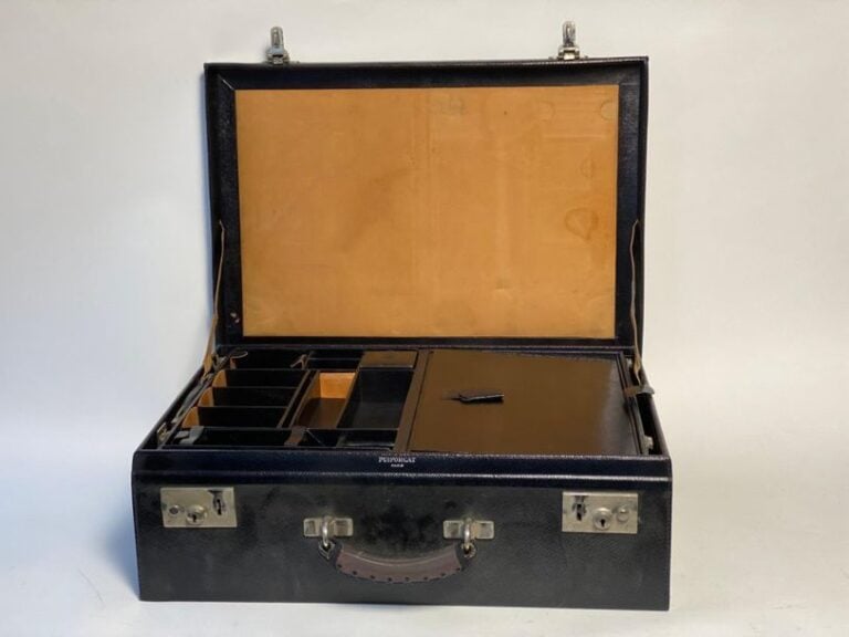 Valise gainée de cuir noir grainé comportant plusieurs compartiments destinés à recevoir un important nécessaire de toilette (manque