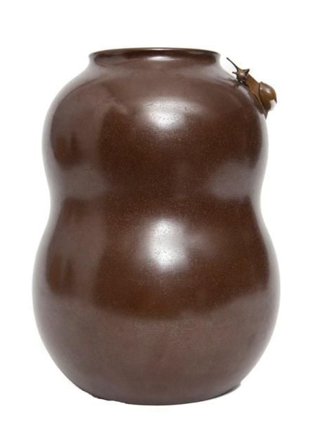 Vase en bronze de couleur foncée en forme d'une gourde sur lequel figure un escargot se dirigeant vers son embouchur