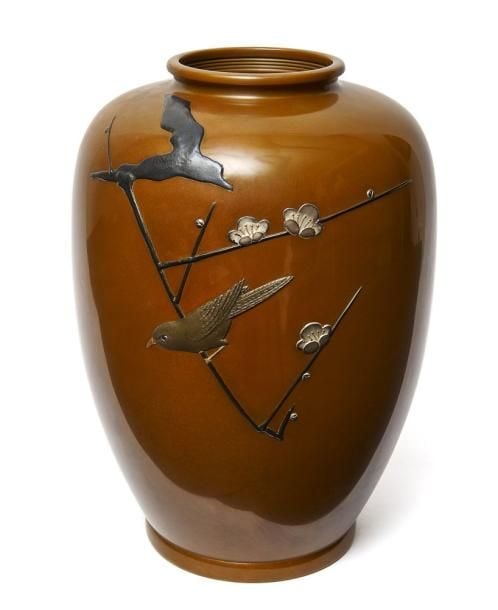 Vase en bronze de grande taille garni d'un relief confectionné à partir de différentes teintes de métal et figurant un oiseau perché sur une branche de fleur de prunie