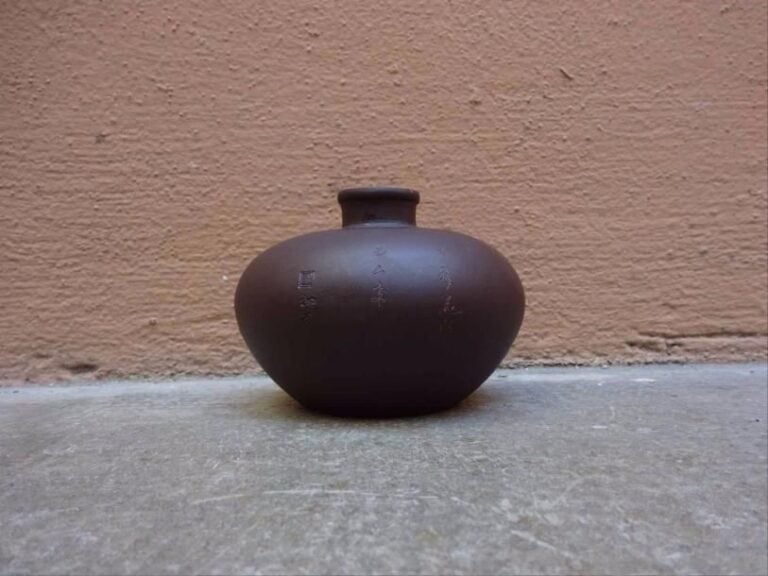 VASE EN FORME DE GRENADE EN TERRE-CUITE DE YIXING Chine, Epoque XXe siècle Frise de volutes au col ; inscription et sceau sur le côté (frottements à la lèvre / égrenures