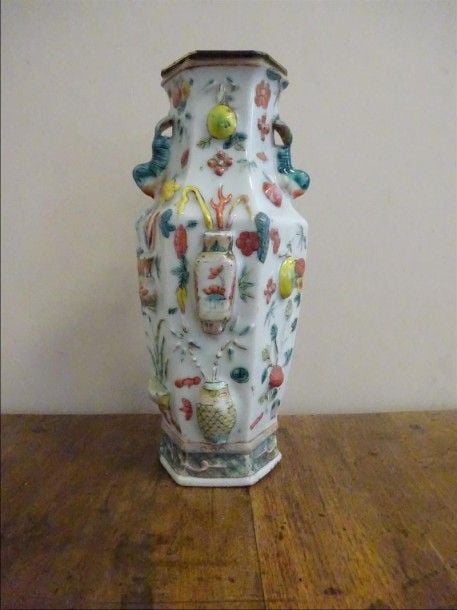 VASE HEXAGONAL EN PORCELAINE DANS LE STYLE DE LA "FAMILLE ROSE" A DECOR MOULE D'OBJETS AUSPICIEUX ET D'ECUREUILS Chine Les anses formant écureuils, décor de pêches, de calebasses et de vases archaïsants, de mains de Bouddh