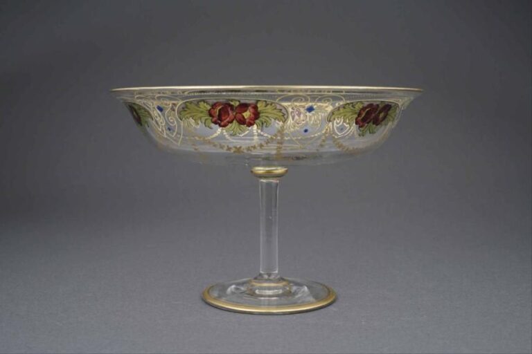 VENISE Coupe sur pied en verre de Murano à décor tournant de guirlandes et semi-médaillons de fleurs polychromes, la dorure à motif de perles et d'arabesques stylisées en léger relie