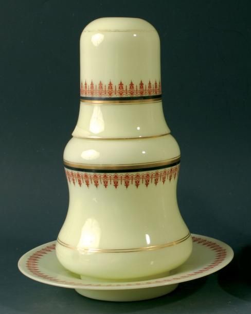 Verre d'eau à l'anglaise composé d'une carafe, de son verre couvrant et d'un présentoir en opaline de cristal jaune à décor de bandeaux de lambrequins rouges et de filets noirs et doré