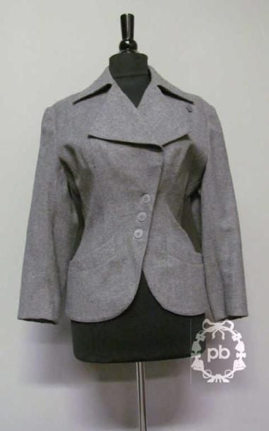 VESTE cintrée à col cranté transformable sur petit boutonnage asymétrique, rappel aux poignets, deux poches verticales (griffe blanche, graphisme noir) (T40)