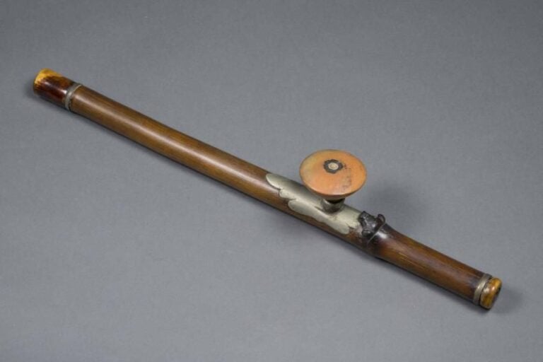 [X] PIPE A OPIUM EN BAMBOU  Chine ou Indochine / Vietnam, Epoque XXe siècle Le fût de la pipe - circulaire et exécuté dans une pièce de bambou - clos à chacune de ses extrémités par des embouts en ivoir