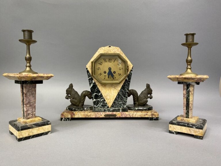 Garniture de cheminée comprenant une pendule en marbre veiné flanqué de deux éc…