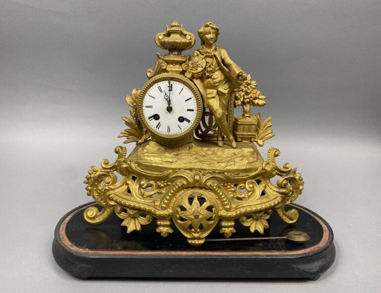 Pendule romantique en régule doré à décor de jeune homme au bouquet - Le mouvem…