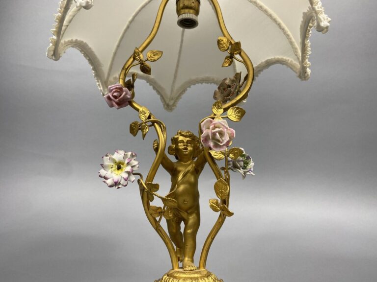 Pied de lampe en bronze doré soutenu par un angelot et ponctué de fleurettes en…