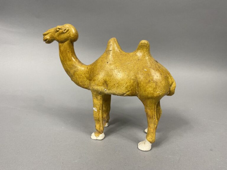 Sujet en terre cuite à glaçure dans les tons jaune figurant un chameau se tenan…