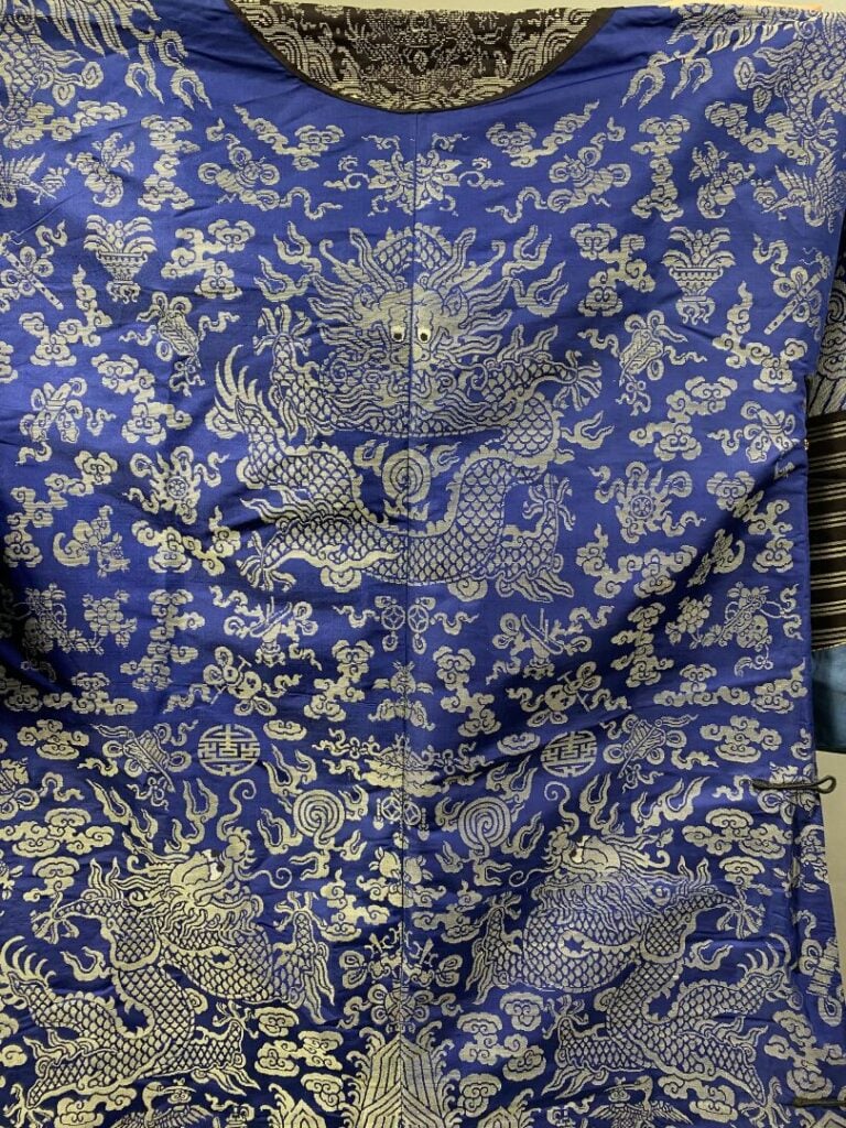 CHINE - XIXe siècle - Robe (jifu) en soie bleue brodée aux fils argentés de dra…