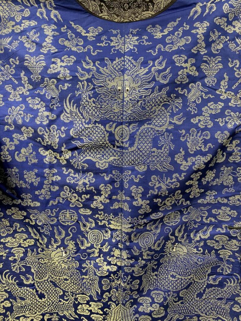 CHINE - XIXe siècle - Robe (jifu) en soie bleue brodée aux fils argentés de dra…