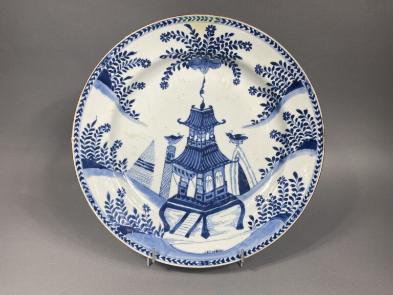 Chine, XVIIIe - Important plat en porcelaine émaillé bleu-blanc, décor de pagod…