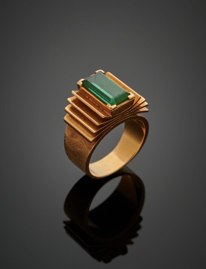 BAGUE « à livre ouvert » en or jaune (750‰) guilloché, serti d'une pierre verte…