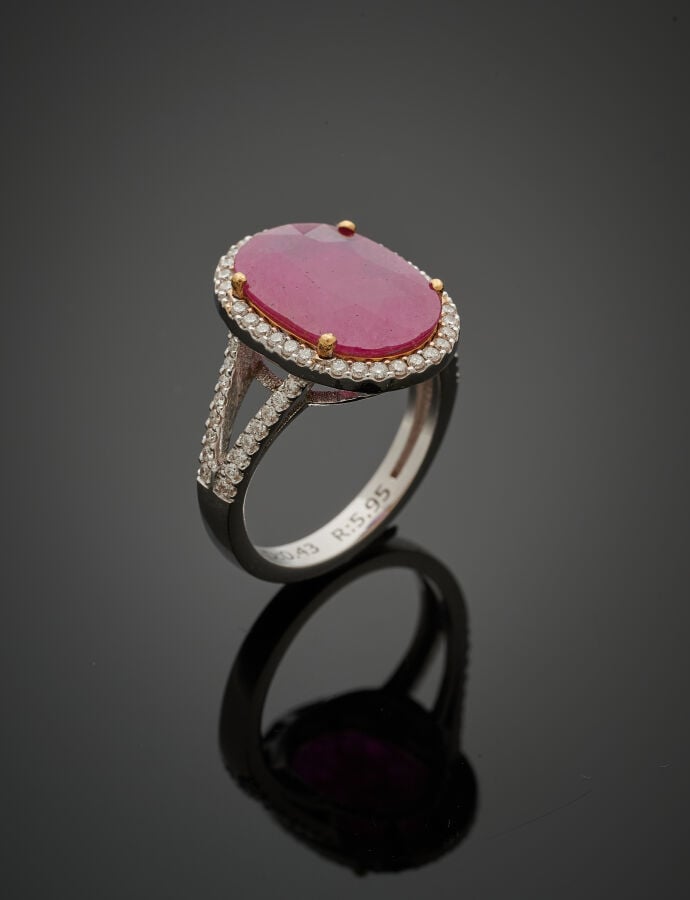 BAGUE en or gris (750‰) ajouré, serti d'un rubis ovale pesant 5,95 carats, ento…