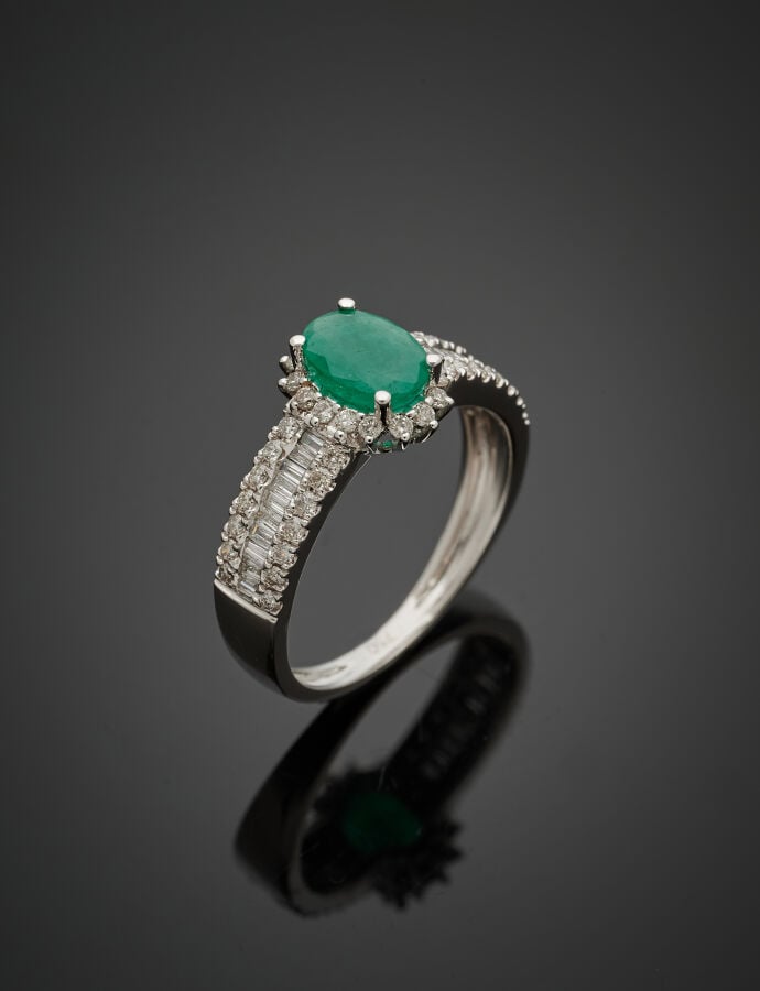 BAGUE en or gris (750‰) serti d'une émeraude ovale, entourée et épaulée de diam…