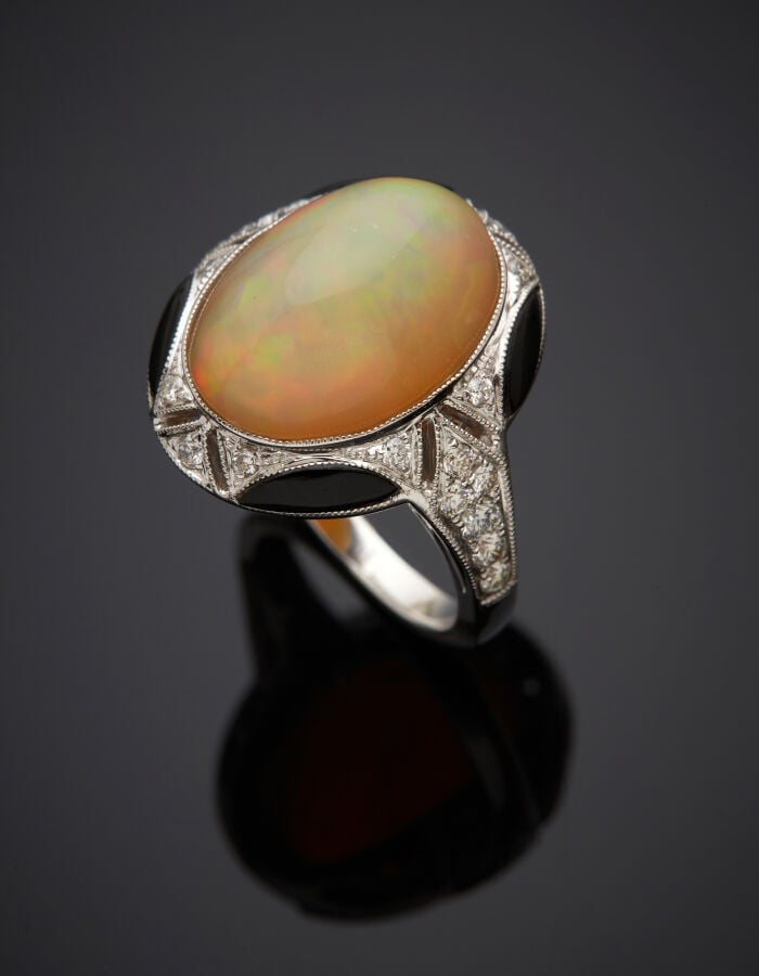 BAGUE ovale en or gris (750‰) ajouré et finement ciselé, serti d'une opale cabo…