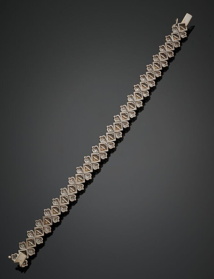 BRACELET articulé en or gris (750‰) serti de diamants taille brillant alternés…
