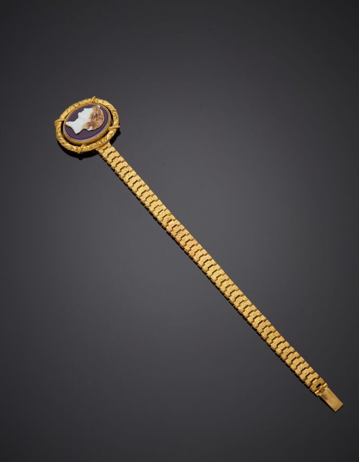 BRACELET en métal doré articulé et ciselé. Fermoir ovale serti d'une imitation…