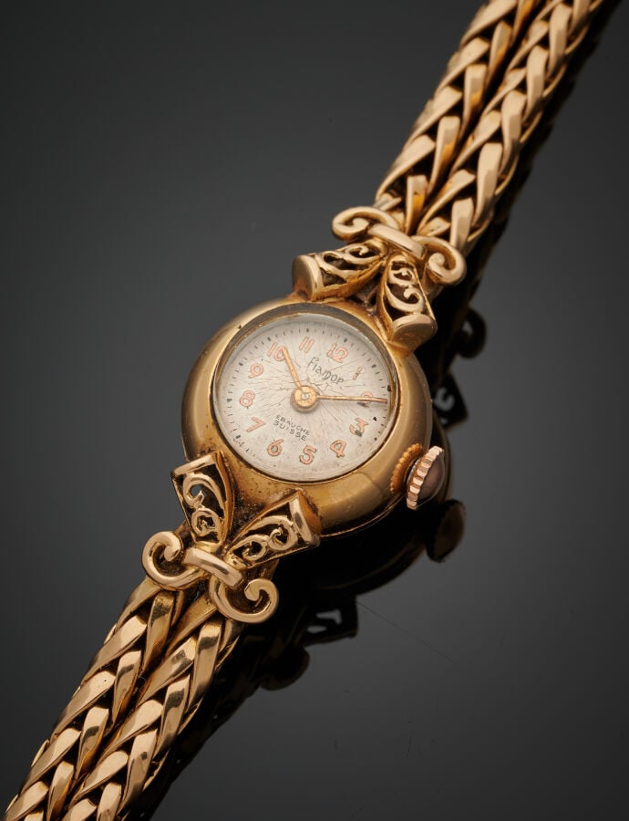 BRACELET MONTRE ronde de dame en or jaune (750‰). Attaches « cornes d'abondance…